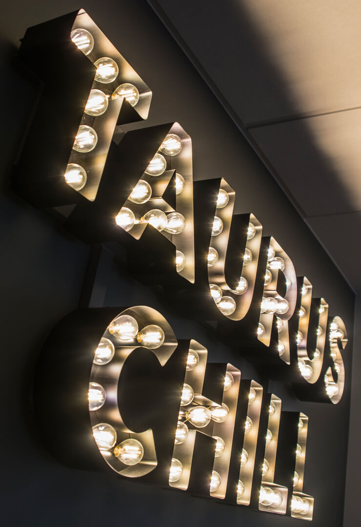 Taurus Chill - letters with light bulbs placed on the wall